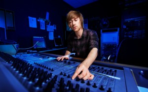 Man using a sound mixing desk in a recording studio